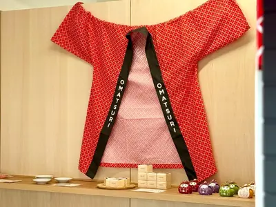 a red shirt with a black tie hanging on a shelf at OMATSURI BASE Nakanoshimbashi in Tokyo