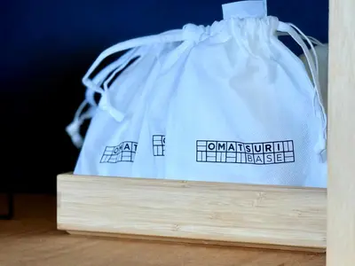 a white plastic bag sitting on top of a table at OMATSURI BASE Nakanoshimbashi in Tokyo