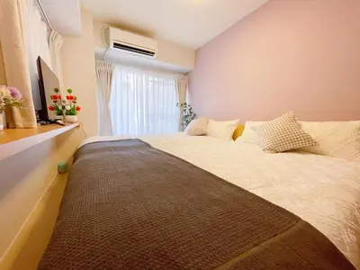 a bedroom with a large bed with a window at \u65b0\u5bbf\u5fa1\u82d1 \u5f92\u6b698\u5206 \u65b0\u5bbf\u4e09\u4e01\u76ee\u99c5\u5f92\u6b698\u5206 WiFi\u7121\u6599 in Tokyo
