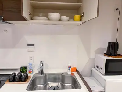 a kitchen with a sink and a microwave at \u65b0\u5bbf\u5fa1\u82d1 \u5f92\u6b698\u5206 \u65b0\u5bbf\u4e09\u4e01\u76ee\u99c5\u5f92\u6b698\u5206 WiFi\u7121\u6599 in Tokyo