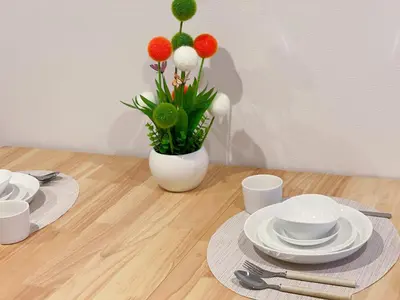 a table with white plates and a vase with flowers at \u65b0\u5bbf\u5fa1\u82d1 \u5f92\u6b698\u5206 \u65b0\u5bbf\u4e09\u4e01\u76ee\u99c5\u5f92\u6b698\u5206 WiFi\u7121\u6599 in Tokyo