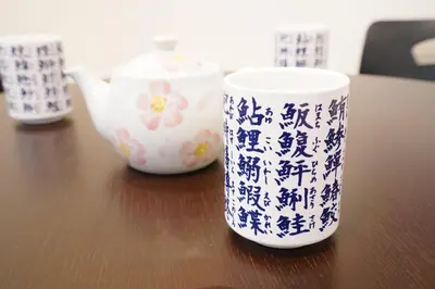 a wooden table with two cups and a tea pot at Chihaya house \u5343\u65e9\u30cf\u30a6\u30b9 in Tokyo