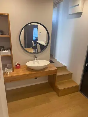 a bathroom with a sink and a round mirror at \u677e\u5c4b\u30db\u30c6\u30eb4\u968e in Tokyo