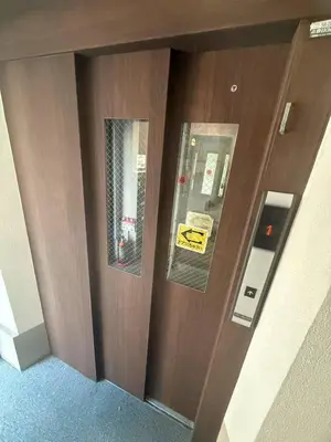 a brown door with a yellow sign on it at \u677e\u5c4b\u30db\u30c6\u30eb4\u968e in Tokyo