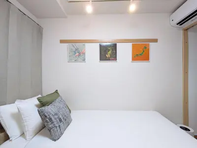 a bedroom with a white bed and some pictures on the wall at Laze Nakano 2bed Travel Work Broadway in Tokyo