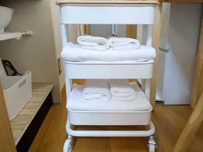 a stack of towels on a towel rack in a closet at Laze Nakano 2bed Travel Work Broadway in Tokyo