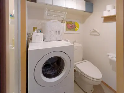 a white washing machine in a bathroom with a toilet at Laze Nakano 2bed Travel Work Broadway in Tokyo