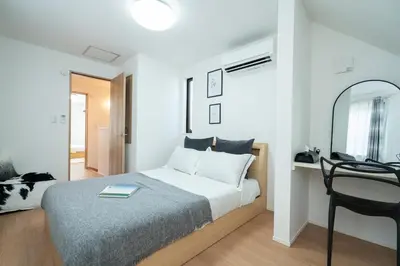 a bedroom with a bed and a table and a mirror at \u65b0\u5bbf\u72ec\u680b4\u5ba4\u8fd1\u6b4c\u821e\u4f0e\u753a\u72ec\u680b\u522b\u5885 in Tokyo