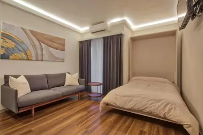 a bedroom with a bed and a couch at STUMP SA Shibuya Shoto in Tokyo
