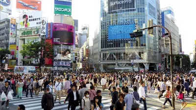 a crowd of people crossing a busy city street at STUMP SA Shibuya Shoto in Tokyo