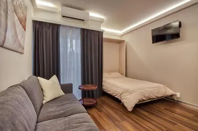 a living room with a couch and a bed at STUMP SA Shibuya Shoto in Tokyo