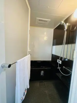 a bathroom with a shower with a toilet and towels at Miyazaki in Tokyo