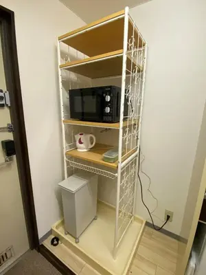 a shelf in a room with a microwave at Minamishinagawa A-yokocho Base in Tokyo