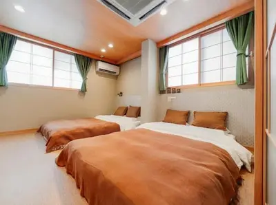 two beds in a room with two windows at Alice \u6c60\u888b\u76ee\u767d\u96c5\u5bbf in Tokyo