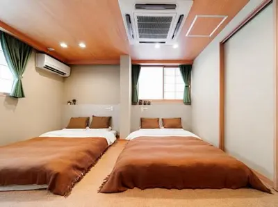 two beds in a room with two windows at Alice \u6c60\u888b\u76ee\u767d\u96c5\u5bbf in Tokyo