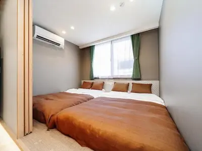 a bedroom with two beds and a window at Alice \u6c60\u888b\u76ee\u767d\u96c5\u5bbf in Tokyo