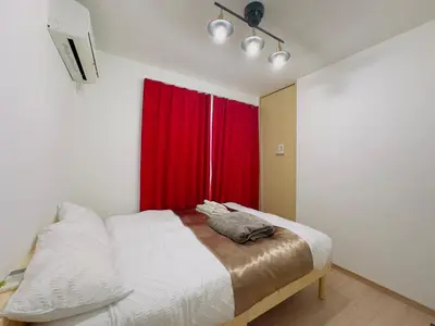 a bedroom with a bed with a red curtain at RelaxKoenjiHouse! 3LDK 4minSta Shinjuku7min Bright,Fun,Cozy! KidsFree Under6yrs in Tokyo