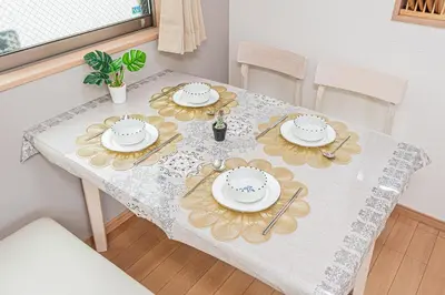 a dining table with plates and utensils on it at Ohanachaya station 5-minute walk 4ldk house maxi 9people family friendly in Tokyo