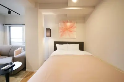 a bedroom with a bed and a couch at 9STAY Shibuya Shinsen in Tokyo