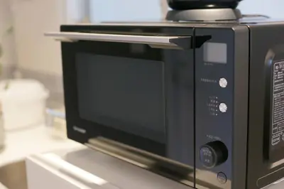 a black microwave oven sitting on top of a counter at 9STAY Shibuya Shinsen in Tokyo