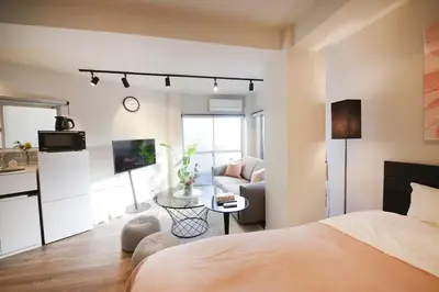 a bedroom with a bed and a living room at 9STAY Shibuya Shinsen in Tokyo