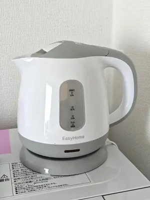 a white electric kettle sitting on top of a table at \u30e1\u30ea\u30b9\u6c60\u888bEast 402 in Tokyo