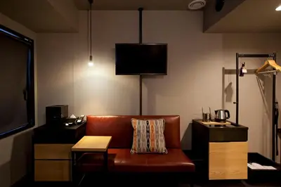 a living room with a leather couch and a tv at Hotel Risveglio Akasaka in Tokyo