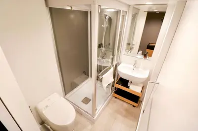 a bathroom with a shower and a toilet and a sink at Hotel Risveglio Akasaka in Tokyo