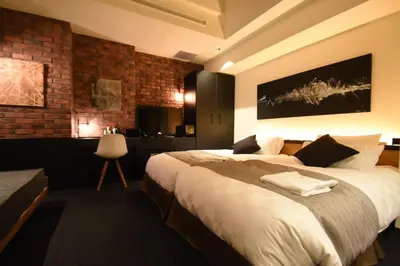 a bedroom with a large bed and a brick wall at Hotel Risveglio Akasaka in Tokyo
