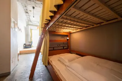 a bedroom with two bunk beds and a window at Imano Tokyo Hostel in Tokyo