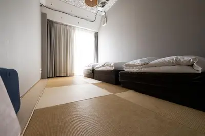 a room with two beds and a window at Imano Tokyo Hostel in Tokyo