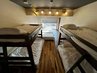 a room with three bunk beds and a window at A nostalgic Japanese atmosphere in Shibuya in Tokyo
