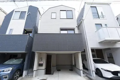 a house with two cars parked in front of it at Happy Home \u6771\u5341\u6761\u99c5\u5f92\u6b697\u5206 \u5341\u6761\u99c5\u3088\u308a\u6c60\u888b\u99c5\u76f4\u901a5\u5206 \u5b50\u3069\u3082\u5927\u559c\u3073\u306e\u6ed1\u308a\u53f0\u3068\u7121\u6599\u99d0\u8eca\u5834\u4ed8\u304d\u4e00\u8ed2\u5bb6 in Tokyo
