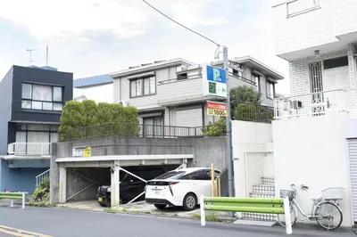 a white car parked in front of a building at Happy Home \u6771\u5341\u6761\u99c5\u5f92\u6b697\u5206 \u5341\u6761\u99c5\u3088\u308a\u6c60\u888b\u99c5\u76f4\u901a5\u5206 \u5b50\u3069\u3082\u5927\u559c\u3073\u306e\u6ed1\u308a\u53f0\u3068\u7121\u6599\u99d0\u8eca\u5834\u4ed8\u304d\u4e00\u8ed2\u5bb6 in Tokyo