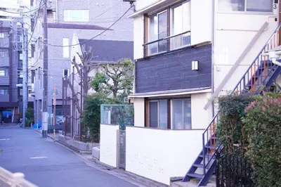 an empty city street with a white building at tonema in Tokyo