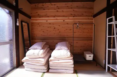 a room with two beds in a room with wooden walls at tonema in Tokyo