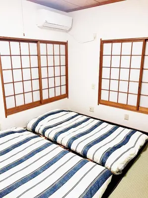 two beds in a room with two windows at Sweet House Sugamo 101 in Tokyo