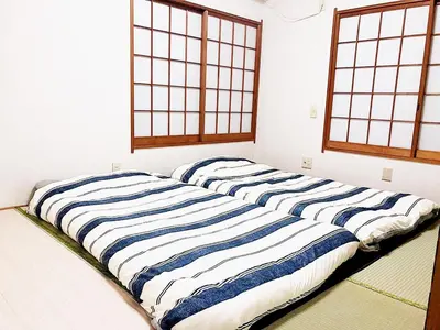 two beds in a room with two windows at Sweet House Sugamo 101 in Tokyo