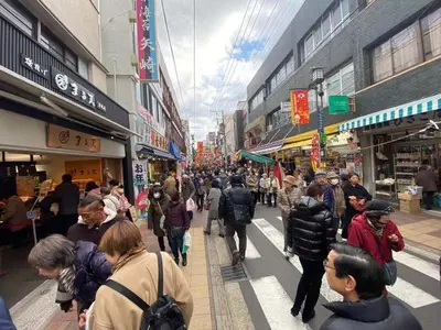 a crowd of people walking down a street in a market at Sweet House Sugamo 101 in Tokyo