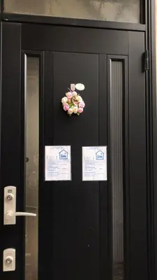 a black door with a bunch of flowers on it at Sweet House Sugamo 101 in Tokyo