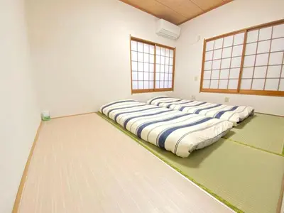 a row of pillows on the floor in a room at Sweet House Sugamo 101 in Tokyo