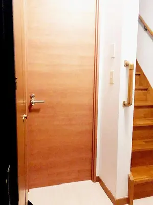 a wooden door leading into a hallway with stairs at Sweet House Sugamo 101 in Tokyo