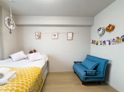 a bedroom with a bed and a blue chair at Yui SAYAKA-SAYAKA 701 Luxury Upper-Floor Stay Near Asakusa in Tokyo