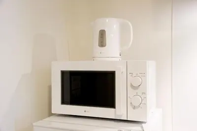 a microwave with a phone on top of it at \u30a2\u30ec\u30b9\u30b0\u30fc\u30c6\u65e9\u7a32\u7530 in Tokyo