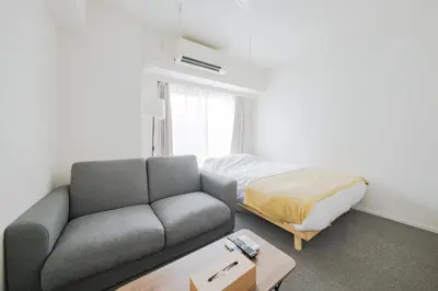 a living room with a couch and a bed at \u30a2\u30ec\u30b9\u30b0\u30fc\u30c6\u65e9\u7a32\u7530 in Tokyo
