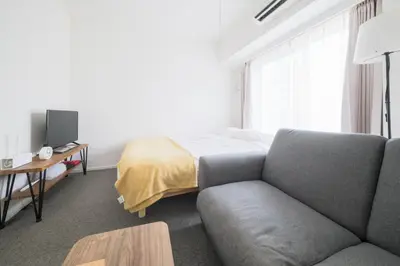 a living room with a couch and a bed at \u30a2\u30ec\u30b9\u30b0\u30fc\u30c6\u65e9\u7a32\u7530 in Tokyo