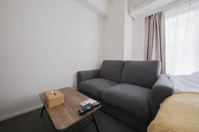 a living room with a couch and a coffee table at \u30a2\u30ec\u30b9\u30b0\u30fc\u30c6\u65e9\u7a32\u7530 in Tokyo