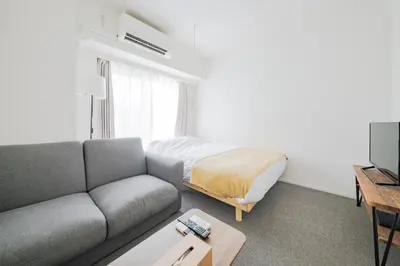 a living room with a couch and a bed at \u30a2\u30ec\u30b9\u30b0\u30fc\u30c6\u65e9\u7a32\u7530 in Tokyo