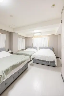 two beds in a bedroom with white floors and windows at Roppongi 3min Walk, Shinjuku 10min,Shibuya 15min, Tokyo Tower 58sqm for 6 in Tokyo