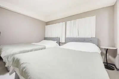 two beds in a room with white sheets and a window at Roppongi 3min Walk, Shinjuku 10min,Shibuya 15min, Tokyo Tower 58sqm for 6 in Tokyo